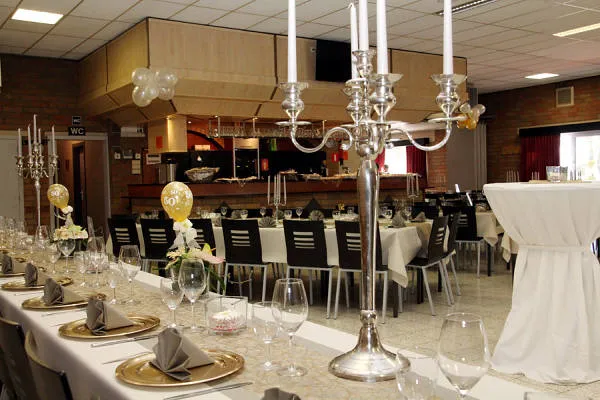 Feestelijk gedekte tafels met kandelaars in zaal Kempengalm