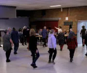 Dansers bij line-dance in zaal Kempengalm