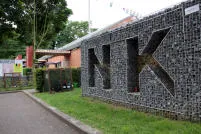 Naambord NK in steenkorven aan de ingang van de wijk